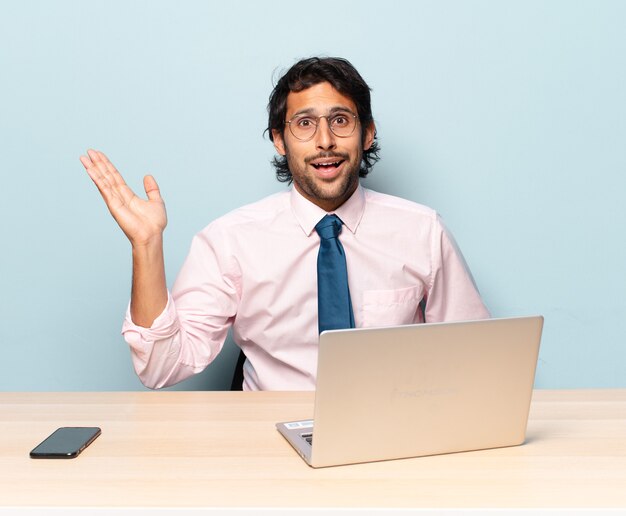 Young handsome indian man feeling happy, surprised and cheerful, smiling with positive attitude, realizing a solution or idea. business and frelancer concept