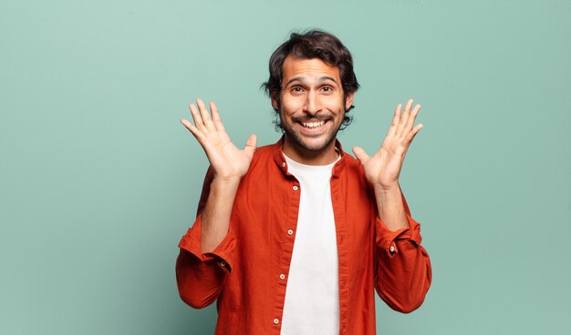 Young handsome indian man feeling shocked and excited