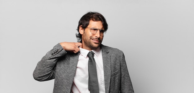 Young handsome indian man feeling stressed, anxious, tired and frustrated, pulling shirt neck, looking frustrated with problem