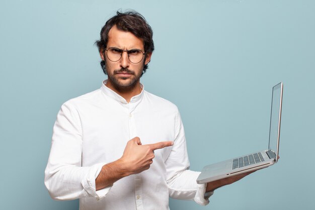 Young handsome indian man holding a laptop. business or social media concept