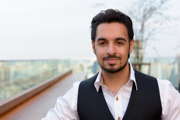 Young handsome Indian man at rooftop restaurant in