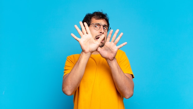 Young handsome indian man scared expression