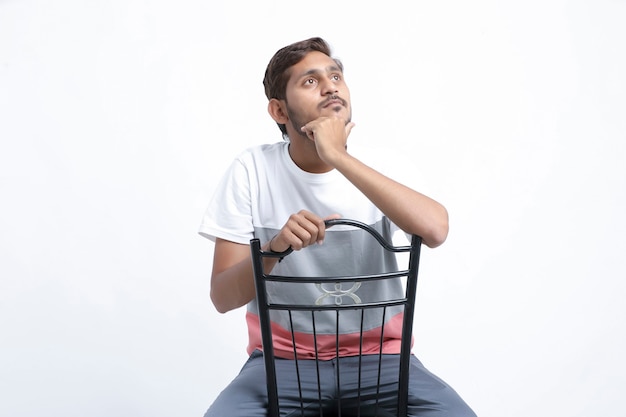 Young handsome Indian man sitting pensive