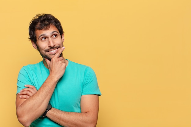 young handsome indian man. thinking or doubting expression