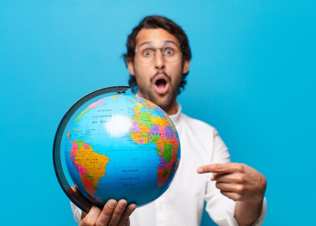 Foto giovane uomo indiano bello con il globo del mondo