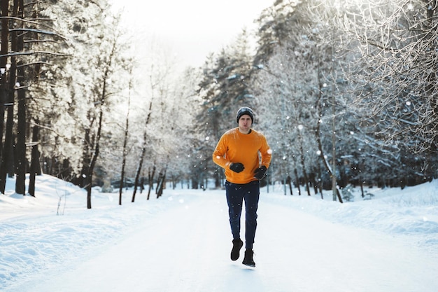 Young and handsome jogger man during his workout in winter
park