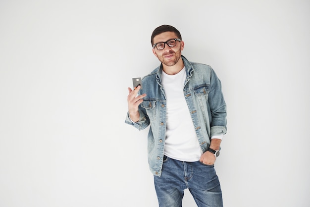 Young handsome male business executive in casual attire holding a credit card in the pockets on a white background. The concept of trading on the Internet and the ease of electronic money.