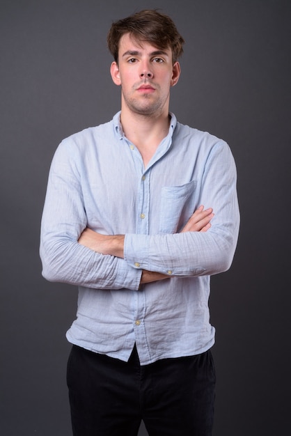 young handsome man against gray wall