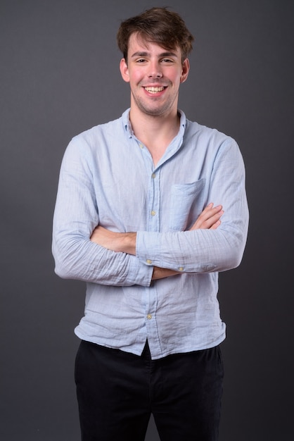 Photo young handsome man against gray wall