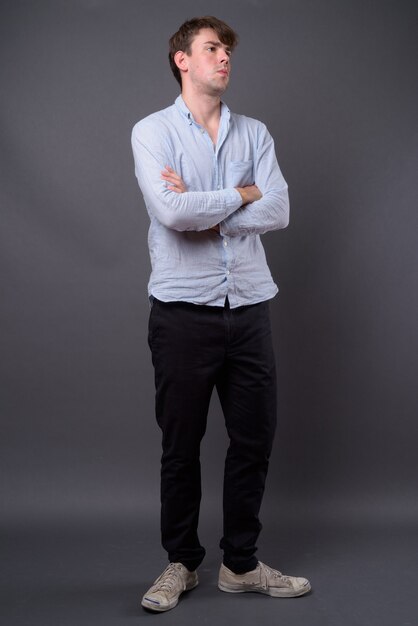 young handsome man against gray wall