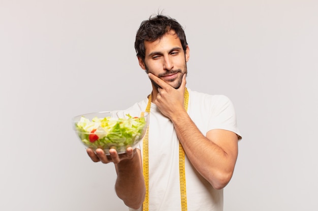 young handsome man against isolated wall