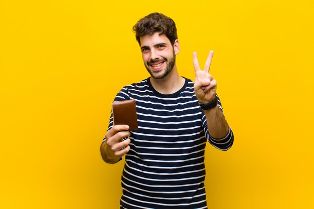 Young handsome man against orange background