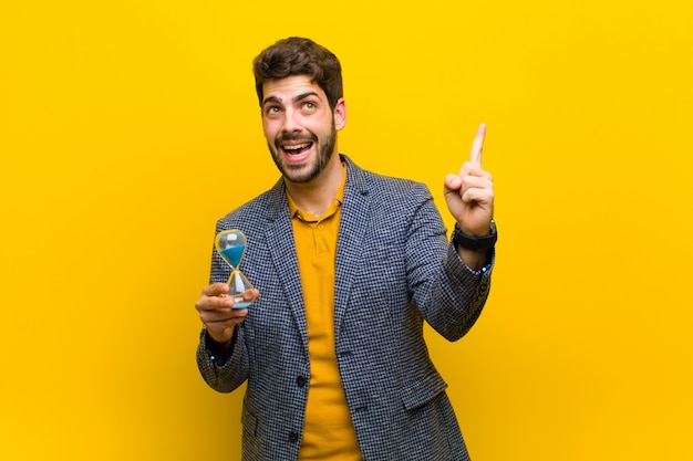 Young handsome man against orange