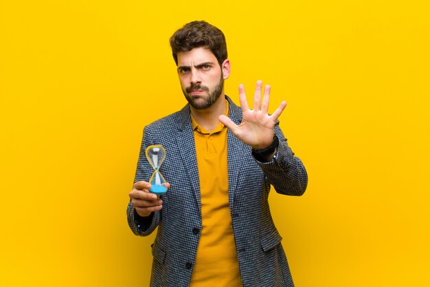 Young handsome man against orange 