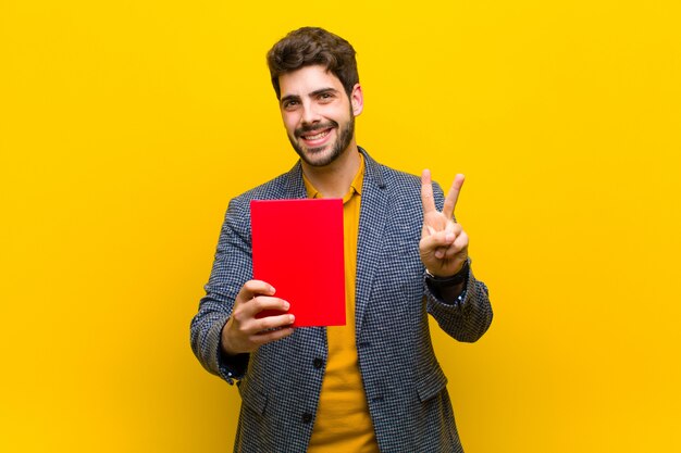 Young handsome man against orange