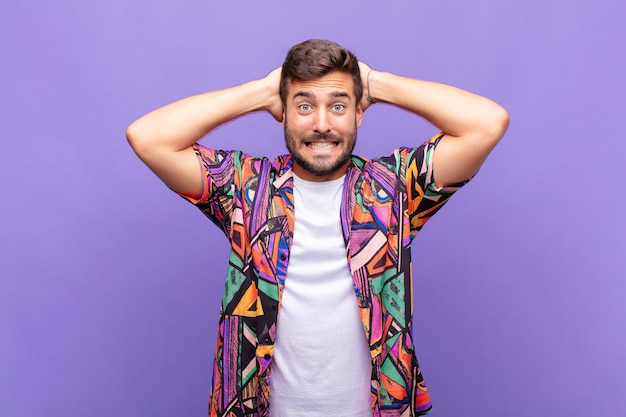 young handsome man against purple wall