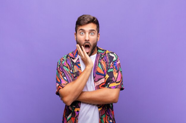 young handsome man against purple wall