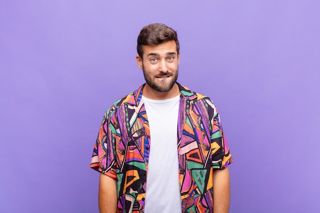 young handsome man against purple wall