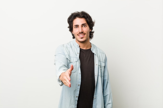 Young handsome man against a white background stretching