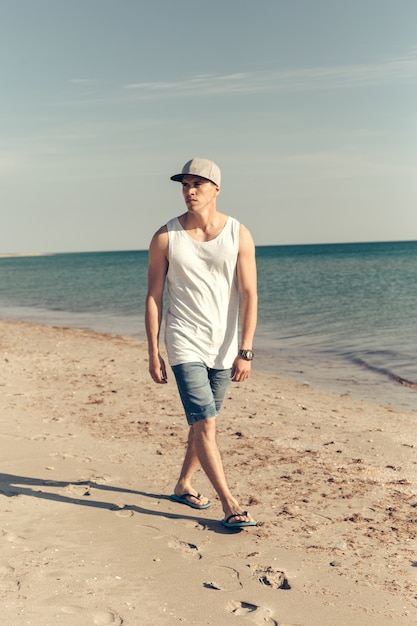 Foto giovane uomo bello sulla spiaggia