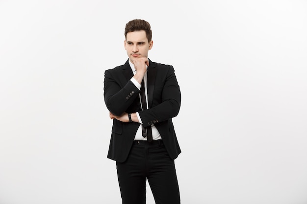 Young handsome man in black suit and glasses looking at copy-space smiling,thinking or dreaming isolated over white background