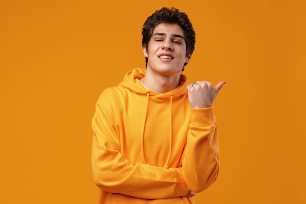 Young handsome man over blue background pointing to the side