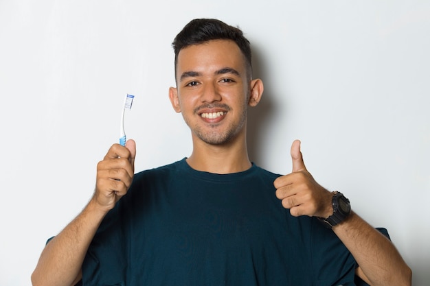 Young handsome man brushing his teeth  isolated on white background