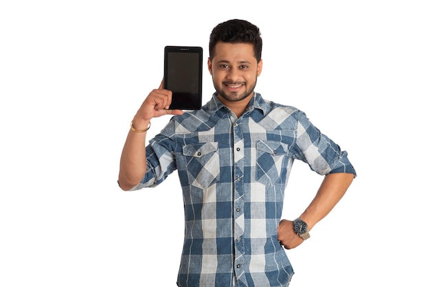 Young handsome man businessman showing a blank screen of a smartphone or mobile or tablet phone on white background