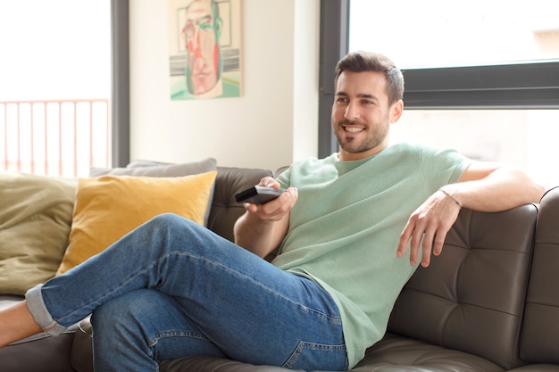 Young handsome man choosing a television channel