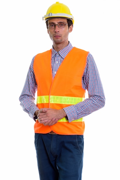 young handsome man construction worker standing with hands together while wearing eyeglasses