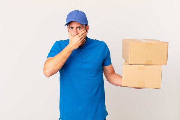 Young handsome man covering mouth with hands with a shocked. package delivering concept