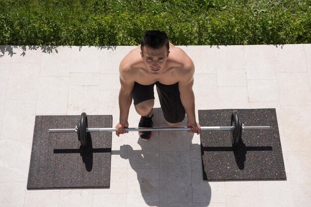 Young handsome man doing morning exercises in front of his luxury home villa