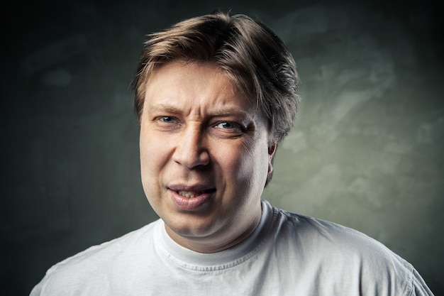 Young handsome man doubting over gray background