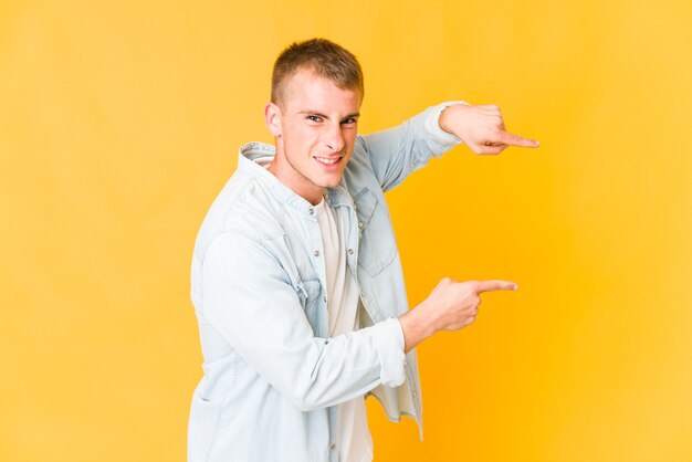 Young handsome man excited pointing with forefingers away