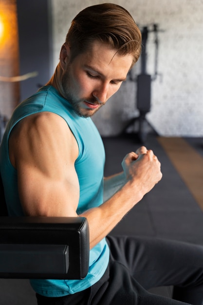 Young handsome man exercising at the gym for bodybuilding