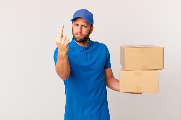 Young handsome man feeling angry, annoyed, rebellious and aggressive. package delivering concept