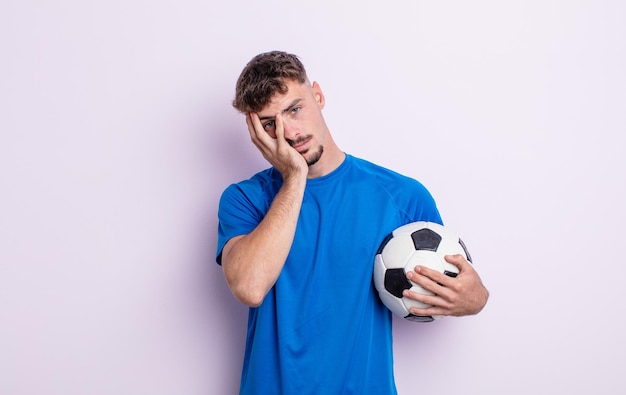 Young handsome man feeling bored, frustrated and sleepy after a tiresome. soccer concept