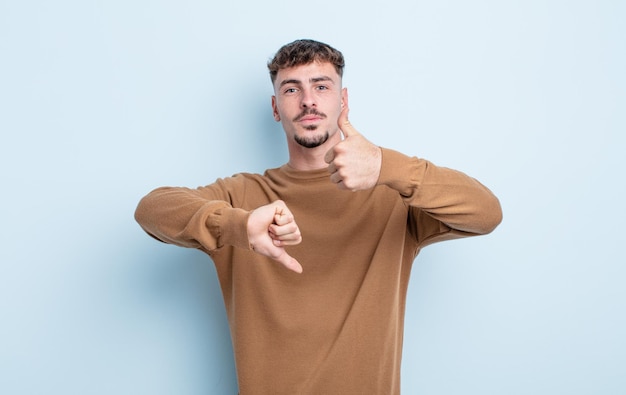 Photo young handsome man feeling confused, clueless and unsure, weighting the good and bad in different options or choices