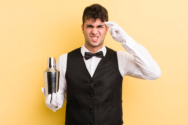 Photo young handsome man feeling confused and puzzled showing you are insane bartender cocktail