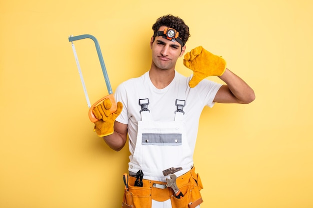 Young handsome man feeling cross,showing thumbs down. handyman repair concept