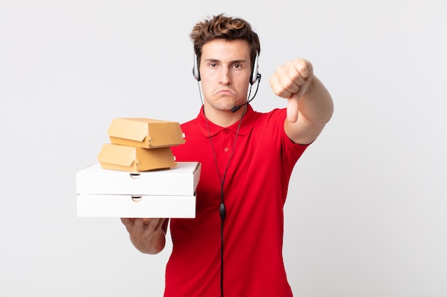 Young handsome man feeling cross,showing thumbs down. take away fast food concept