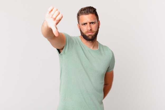 Young handsome man feeling cross,showing thumbs down