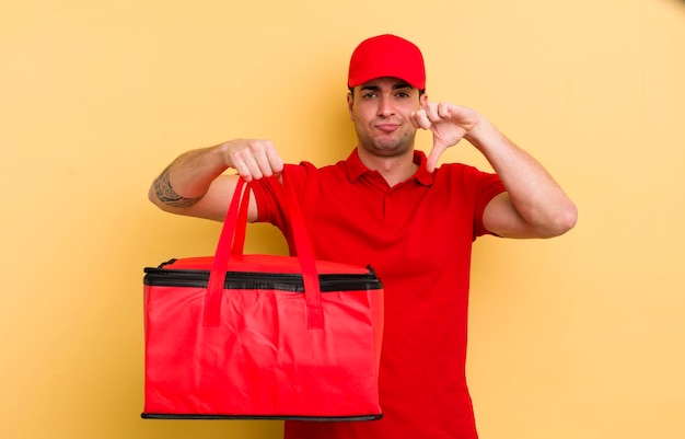 Young handsome man feeling crossshowing thumbs down pizza courier concept