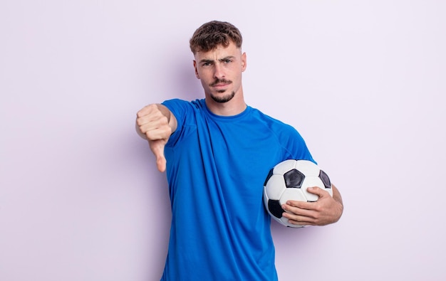 Young handsome man feeling crossshowing thumbs down soccer concept