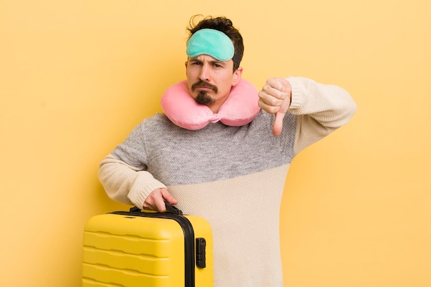 Young handsome man feeling crossshowing thumbs down travel passenger concept