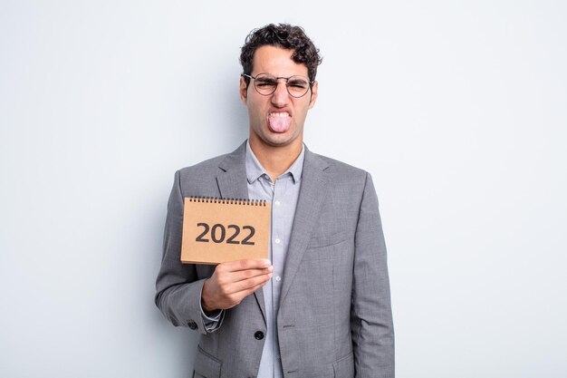 Young handsome man feeling disgusted and irritated and tongue out. calendar concept