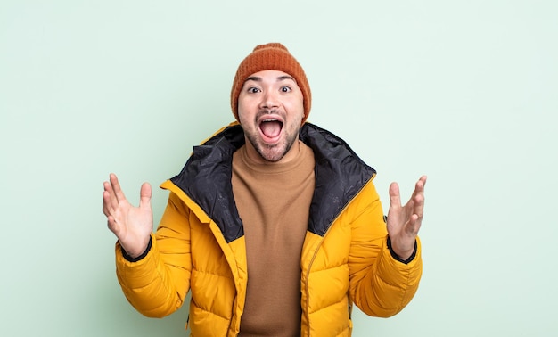 Young handsome man feeling extremely shocked and surprised. cold weather concept