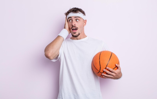 Young handsome man feeling happy, excited and surprised. basketball concept