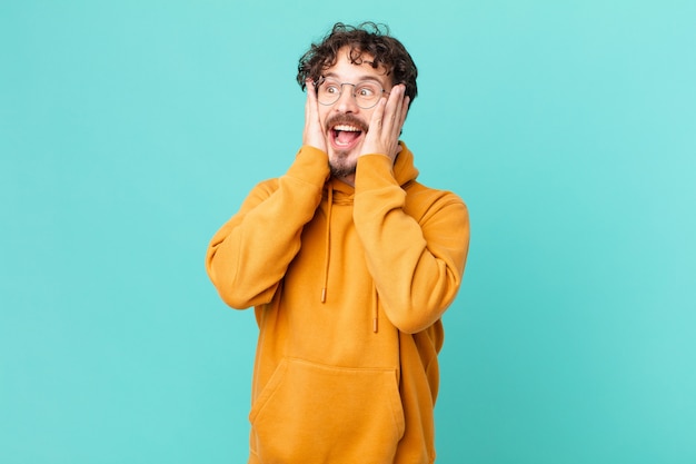 Young handsome man feeling happy, excited and surprised