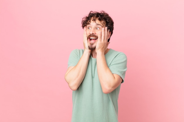 Young handsome man feeling happy, excited and surprised